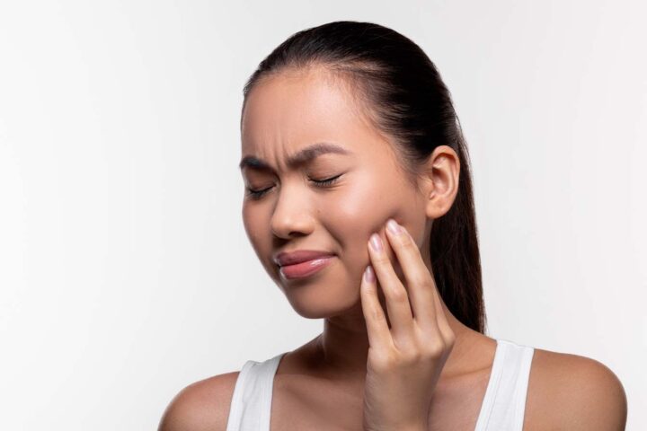 woman experiencing tooth ache/ tooth pain